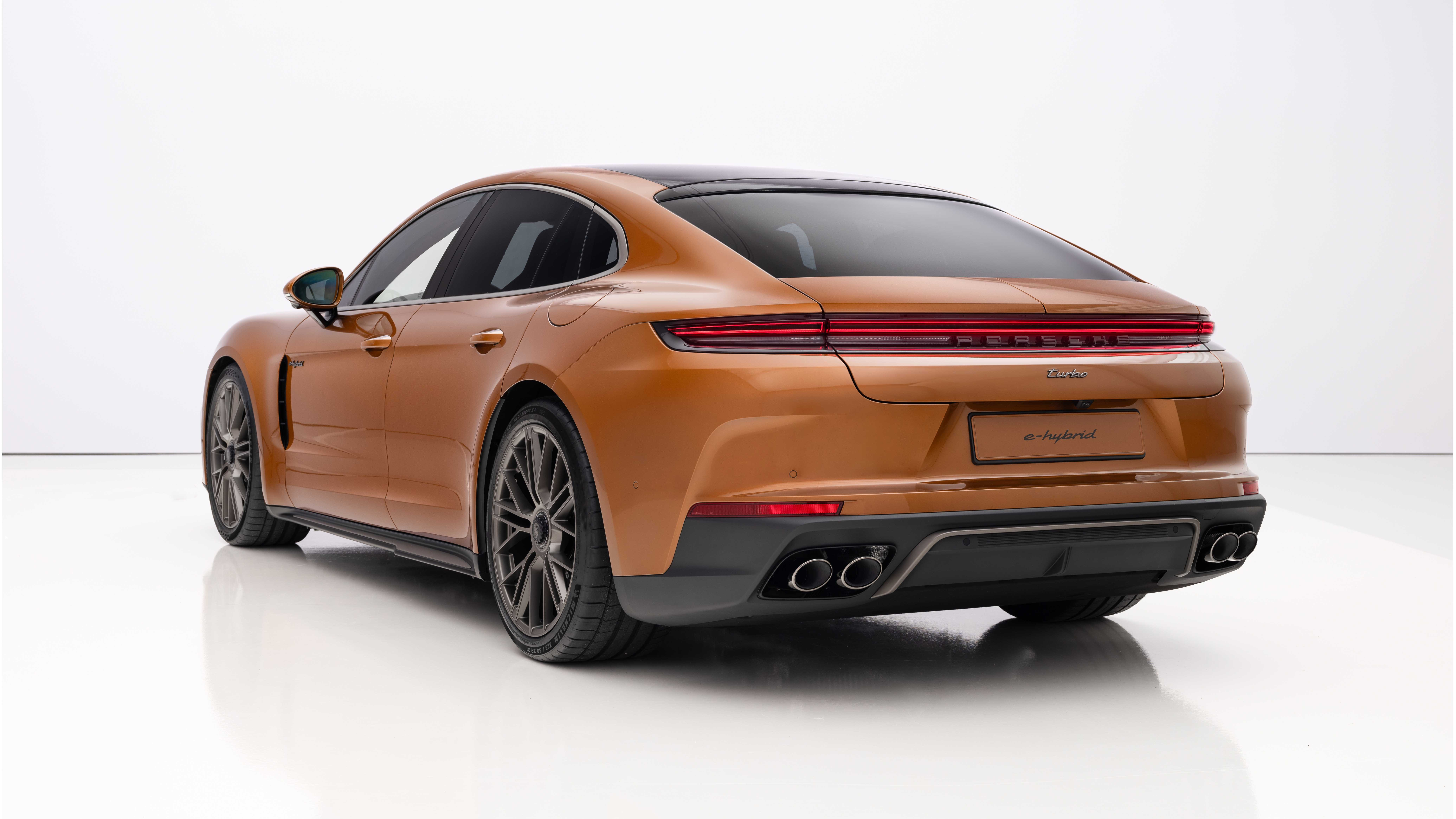 Rear 3/4 view of an orange 2024 Porsche Panamera